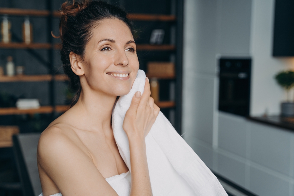 Attractive,Hispanic,Woman,Is,Wiping,Face,With,Towel,After,Washing.