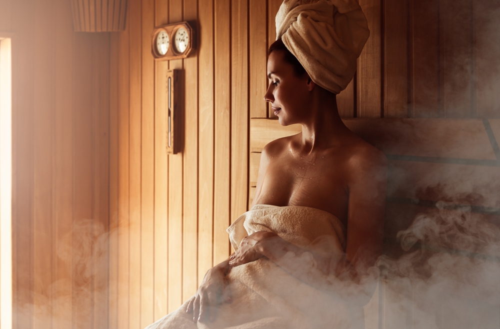 Young,Woman,Relaxing,And,Sweating,In,Hot,Sauna,Wrapped,In
