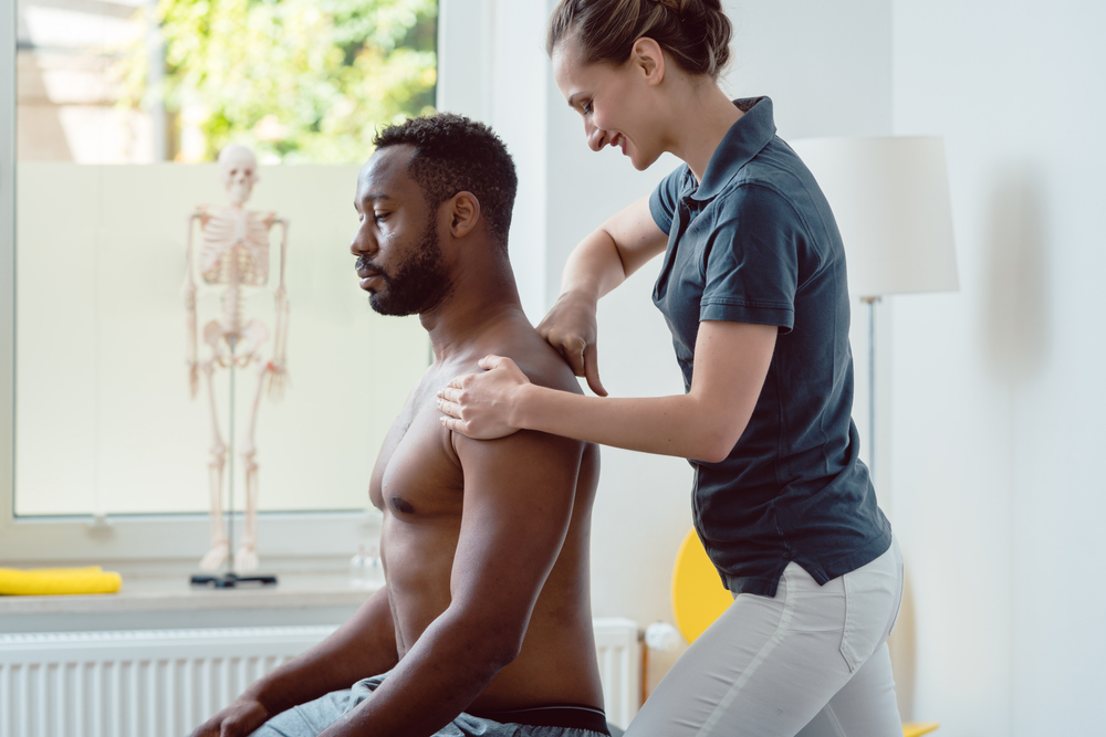 Physical,Therapist,Massaging,A,Young,Black,Man,On,Shoulder,After